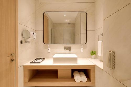 a bathroom with a sink and a mirror at Keys Select by Lemon Tree Hotels, Amritsar in Amritsar