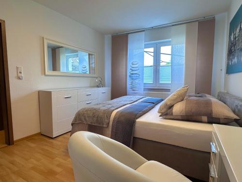 a bedroom with two beds and a chair and a window at Wasserburg 1 I Familienfreundlich - Ruhig & Erdgeschoss I Parkplatz inkl in Paderborn