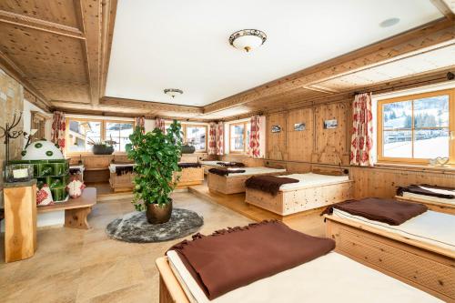 a room with several beds and a potted plant at Hotel Alpenrose in Zauchensee