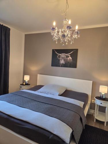 a bedroom with a bed and a chandelier at Mutti 's Haus -Zur Südheide in Wahrenholz