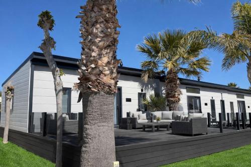 a house with palm trees in front of it at Resort Camping Almafrá in Benidorm