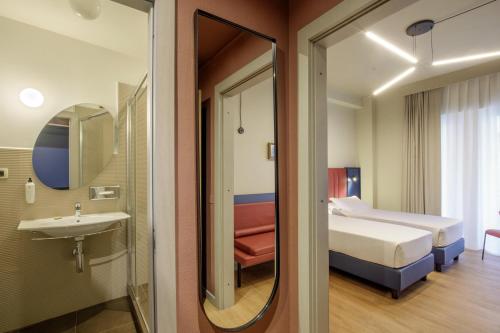 a bathroom with a bed and a sink and a mirror at Best Western Plus Hotel Globus in Rome