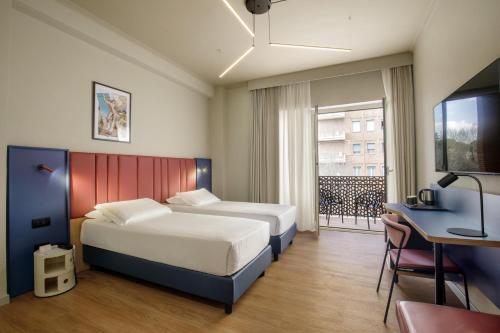 a hotel room with two beds and a desk and a window at Best Western Plus Hotel Globus in Rome