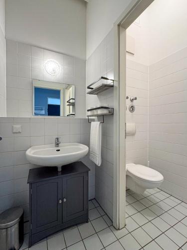 a white bathroom with a sink and a toilet at City-Apartment Timeless in Berlin