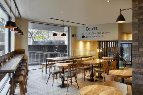 a restaurant with wooden tables and chairs and a window at hub London - Tower Bridge in London