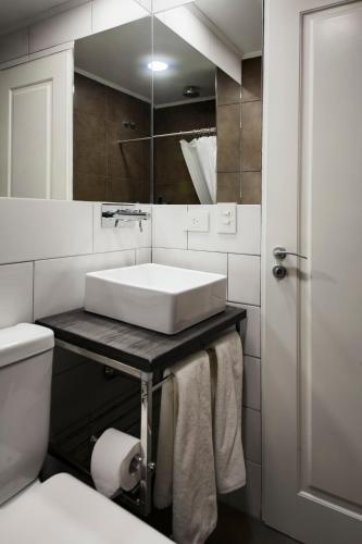 a white bathroom with a sink and a toilet at Hotel Alto San Isidro in San Isidro