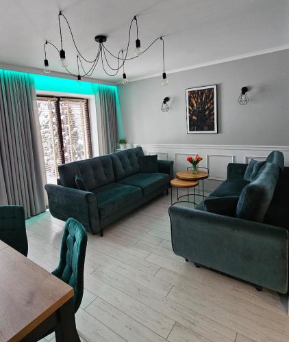 a living room with green couches and a table at Apartament Sun Hill in Wisła