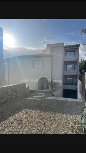a white house with a stone wall and a building at Domu sa luna mia in Villasimius