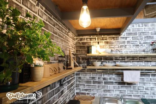 a kitchen with a sink and a brick wall at Olive Branch in Dullstroom