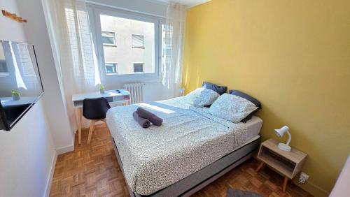 a bedroom with a bed with a yellow wall at Le Repaire - Hyper centre, 3 ch, balcon et parking in Le Mans