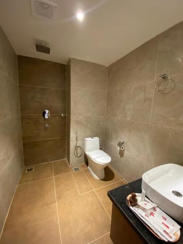 a bathroom with a toilet and a sink and a shower at Landmark Narayani in Chitwan