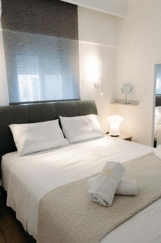 a bedroom with a large white bed with white pillows at Nuance Residences - Cresento in Volos