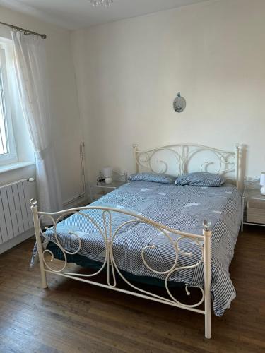 a bedroom with a white bed with a metal frame at Gîte de Lasdoumingeas in Ladignac-le-Long