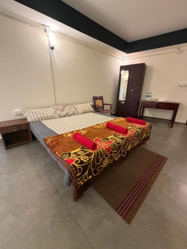 a bedroom with a bed with red pillows on it at Bliss Stay in Mūvattupula