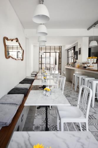 a dining room with white tables and white chairs at Hotel Alto San Isidro in San Isidro