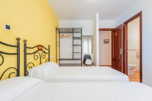 a bedroom with a white bed and a bathroom at Hotel El Horno in La Puebla de Valverde