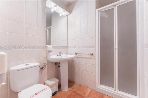 a bathroom with a toilet and a sink and a shower at Hotel El Horno in La Puebla de Valverde