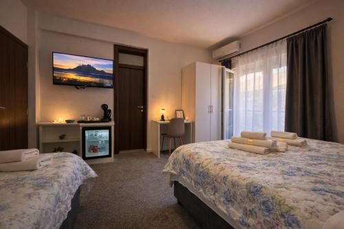 a hotel room with two beds and a television at Apartments Miš in Trebinje