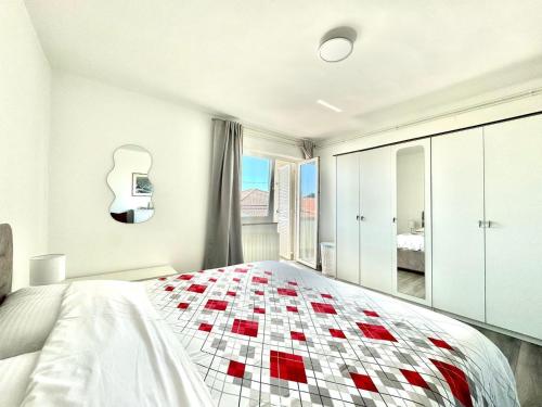 a bedroom with a bed with a red and white quilt at Adrijana 2 in Krk