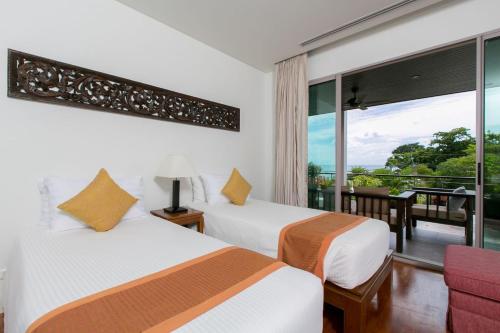 a hotel room with two beds and a balcony at Kata Gardens Penthouse sea view 4C near Kata Noi Beach in Kata Beach