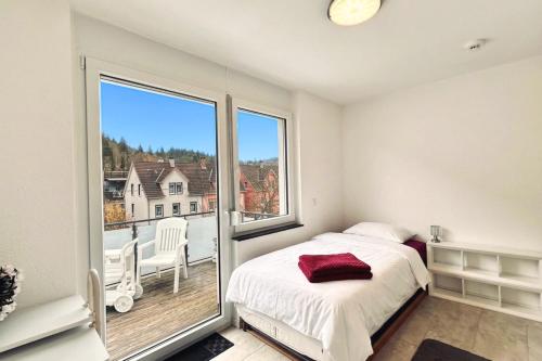 a bedroom with a bed and a large window at Loft Nagoldtal in Pforzheim