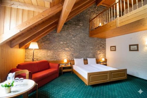 a hotel room with a bed and a couch at Hotel guter Hirte in Huttwil