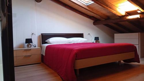 a bedroom with a large bed with a red blanket at Appartamento Trezzo sull'Adda in Trezzo sullʼAdda