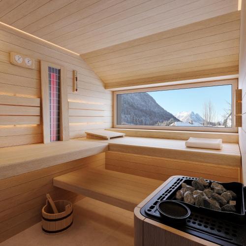 a sauna with a stove and a window at NOOK - Nature Hideaway in Bad Aussee