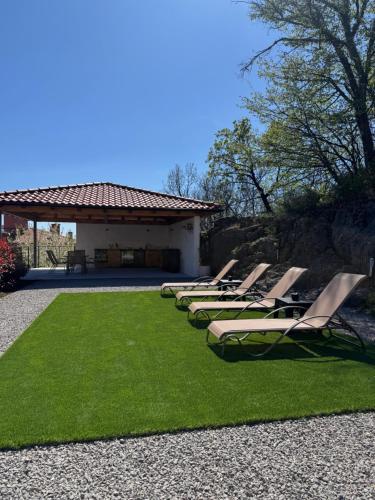 a row of lounge chairs sitting on a lawn at Villa Petra in Kastav