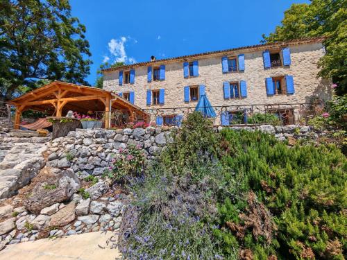 an external view of a building with a stone wall at Les Sources chambres dhotes in Bargème
