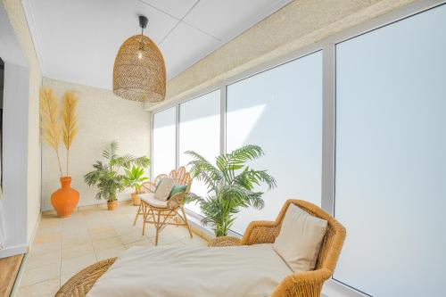 a bedroom with a bed and a large window at Ô Bel Appart, piscine privée & BBQ, ambiance balinaise in Les Cocos