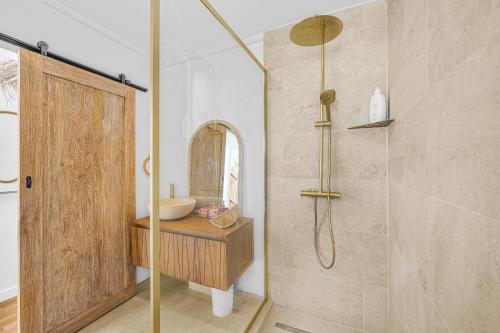 a bathroom with a shower with a glass door at Ô Bel Appart, piscine privée & BBQ, ambiance balinaise in Les Cocos