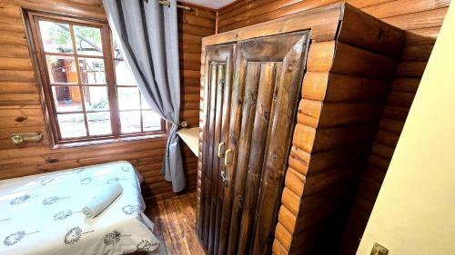 a room with a wooden cabin with a bed and a window at Fairhaven Guest House in Klerksdorp