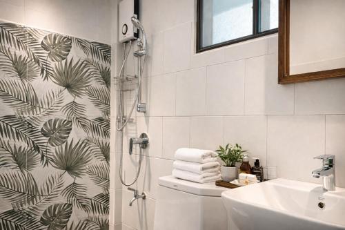 a bathroom with a shower and a sink at Palin Family Cottage in Chiang Rai
