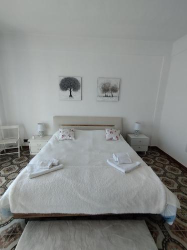a bedroom with a large bed with two towels on it at Karina in Carini
