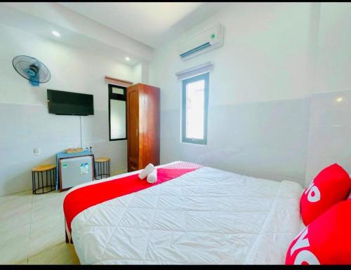 a bedroom with a red and white bed and a tv at Tây Nguyên hotel Đà Nẵng in Danang