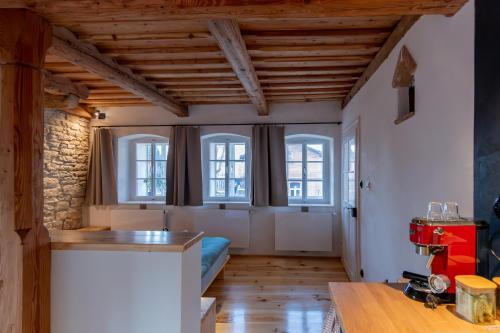 a kitchen with white walls and wooden ceilings and windows at Königův mlýn in Úštěk