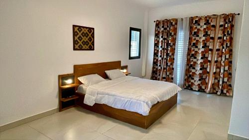a bedroom with a bed in a room at Le Refuge, Residence Ibrahima in Rufisque