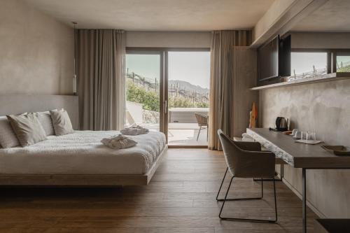 a hotel room with a bed and a desk and a kitchen at Locanda MaMaGiò in Valdobbiadene