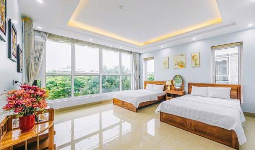 a bedroom with two beds and a large window at FLC Sam Son Grand Pool Villa NT48 7BR Near Beach in Sầm Sơn