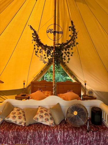 a bed in a tent with a fan at Tiszaglamping, the belgian hideaway in Tiszacsege