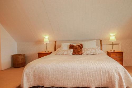 a bedroom with a large bed with two lamps at Poldue House in Camelford