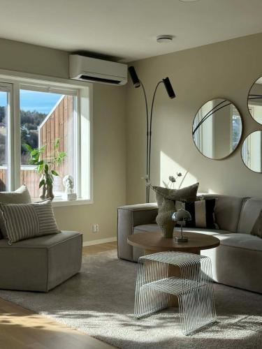 a living room with a couch and a table and a mirror at Modern and stylish home in Bergen