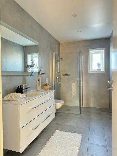 a bathroom with a sink and a shower and a toilet at Modern and stylish home in Bergen