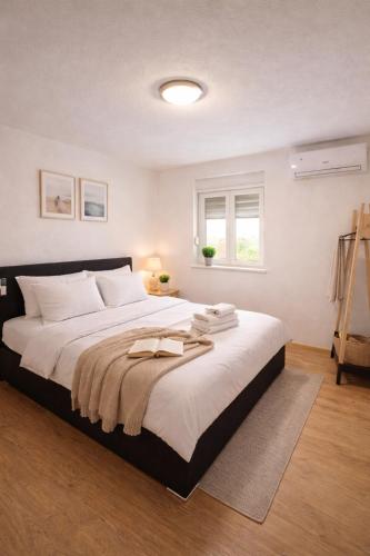 a bedroom with a large bed with towels on it at GUESTHOUSE Kastel Novi 2 More Space in Kaštela
