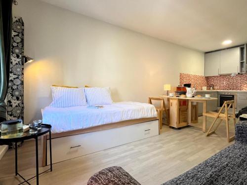 a bedroom with a bed and a small kitchen at Santiago Apartment in Caminha