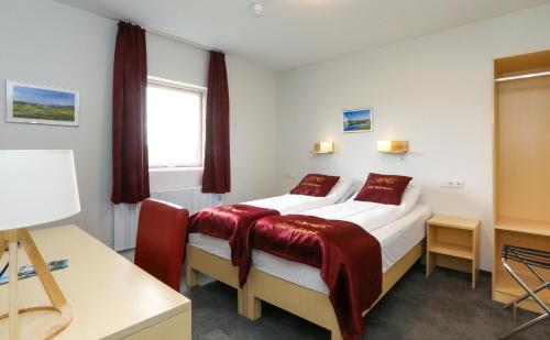 a hotel room with two beds and a window at Hótel Eyjafjallajökull in Hvolsvöllur