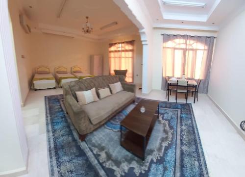 a living room with a couch and a coffee table at Private Rooms For Rent Near Airport - Raha Hostel in Ḩayl Āl ‘Umayr