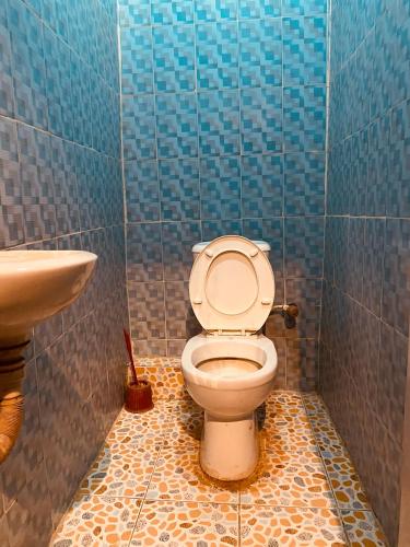 a bathroom with a toilet and a sink at Executive 2BR at Redemption Camp in Loburo
