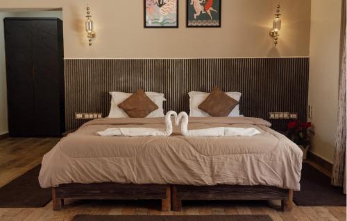 a bedroom with a bed with white towels on it at Wild Woods Tiger Resort in Nagpur